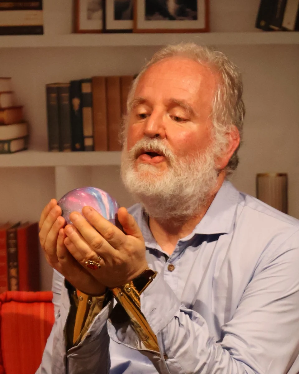 Christophe Pradel sur scène, tenant une boule colorée entre ses mains